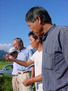 熱塩加納村の田圃、ＪＡＳ有機認定生産者どうし話題は尽きない。 手前から菅井さん、松下くん、玄さん、高野くん。